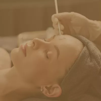 Woman receiving a facial brush skincare treatment at a spa